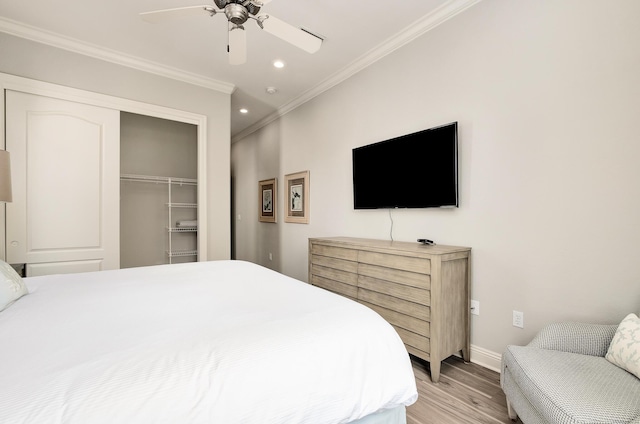 bedroom with ceiling fan, a closet, light hardwood / wood-style floors, and ornamental molding