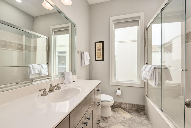 full bathroom featuring vanity, toilet, and bath / shower combo with glass door