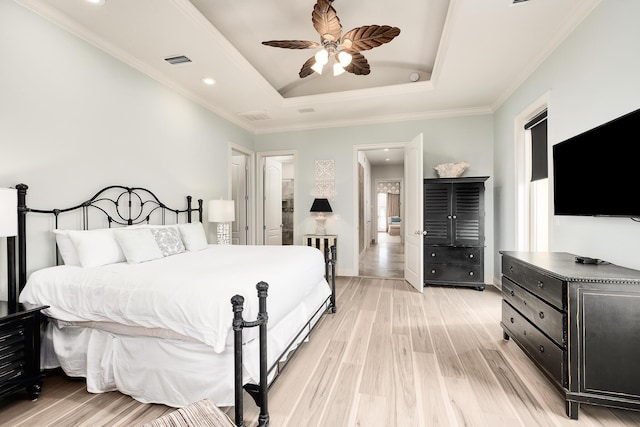 bedroom featuring a tray ceiling, light hardwood / wood-style flooring, ceiling fan, and crown molding