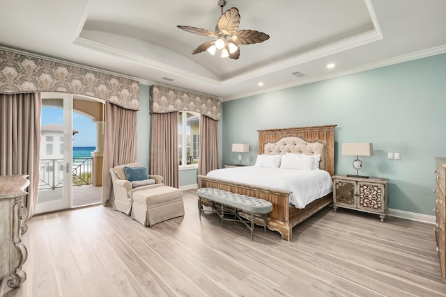 bedroom with a raised ceiling, access to outside, light hardwood / wood-style flooring, and ceiling fan