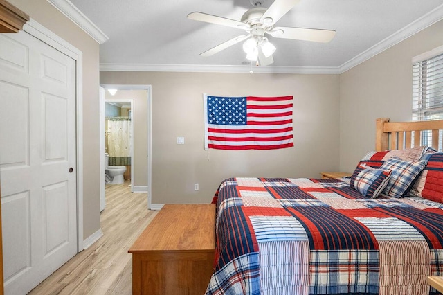 bedroom with light wood-type flooring, ceiling fan, crown molding, and connected bathroom