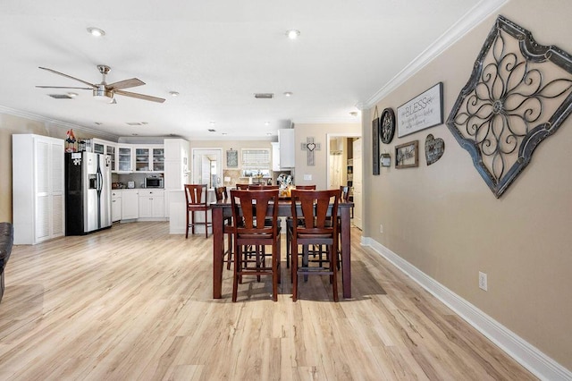 dining space with ceiling fan, light hardwood / wood-style flooring, and crown molding