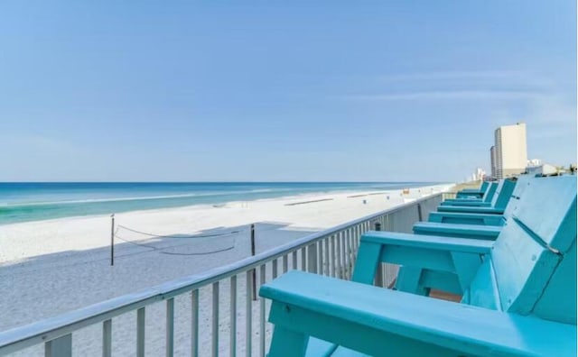 balcony with a water view and a view of the beach