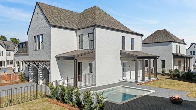 rear view of property with a yard, a pergola, and a patio