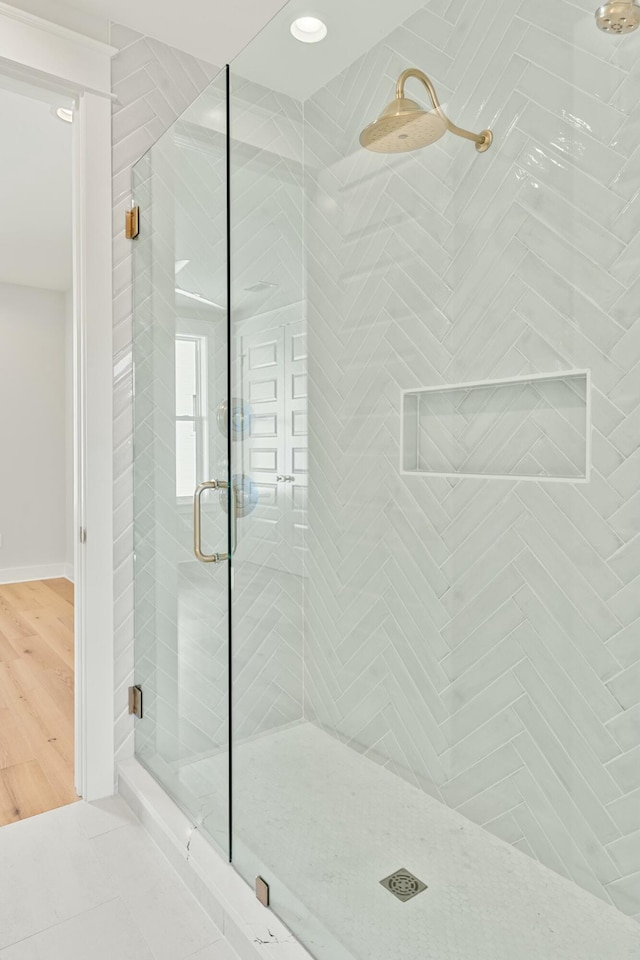 bathroom featuring hardwood / wood-style floors and a shower with door