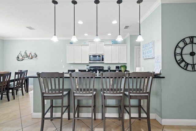 kitchen featuring a kitchen bar, black / electric stove, white cabinetry, and hanging light fixtures