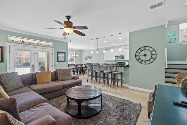 living room with a textured ceiling, ceiling fan, and crown molding