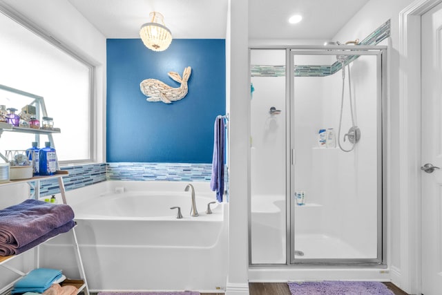 bathroom featuring wood-type flooring and shower with separate bathtub