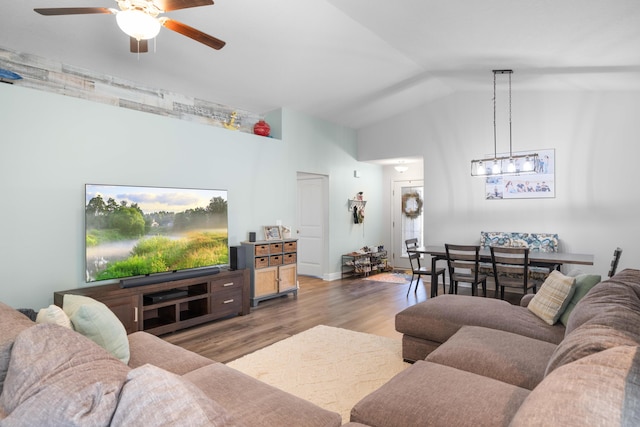 living room with hardwood / wood-style flooring, ceiling fan, and lofted ceiling