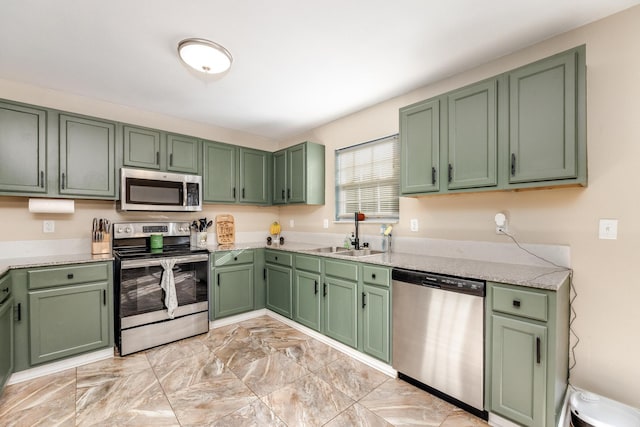 kitchen with appliances with stainless steel finishes, green cabinetry, and sink