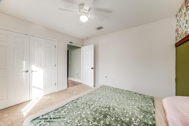 carpeted bedroom with ceiling fan and a closet