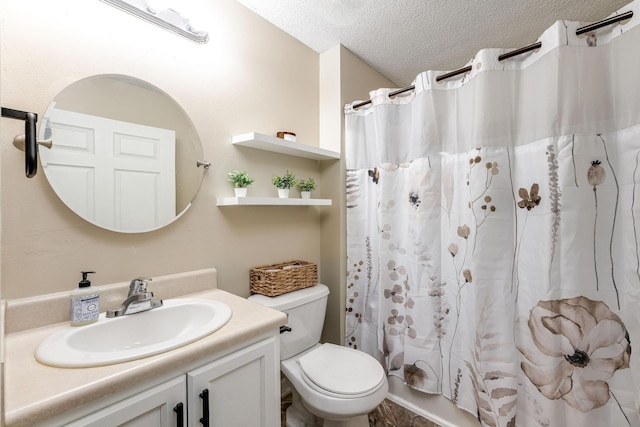 bathroom with vanity, toilet, and a textured ceiling