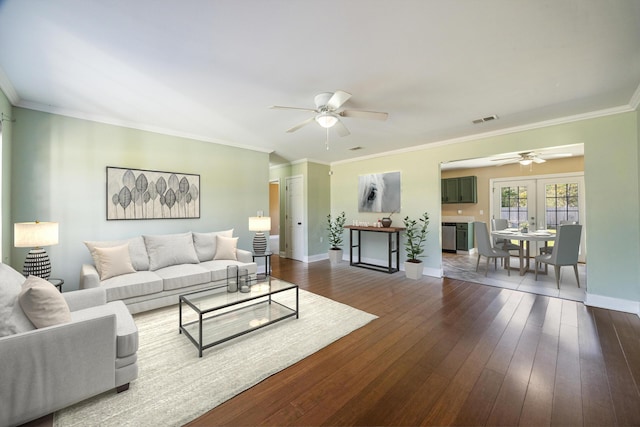 living room with a ceiling fan, baseboards, visible vents, ornamental molding, and dark wood-style flooring