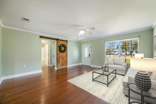 living room with visible vents, crown molding, hardwood / wood-style flooring, ceiling fan, and a barn door