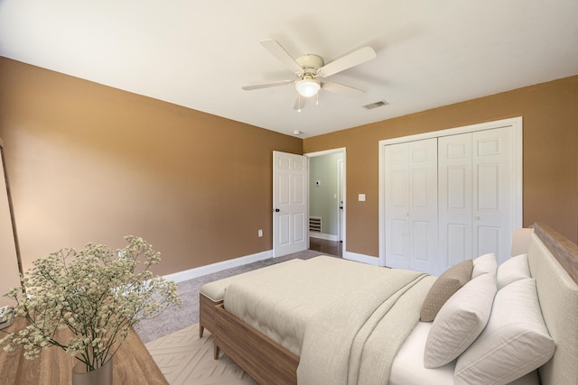 carpeted bedroom with baseboards, ceiling fan, visible vents, and a closet