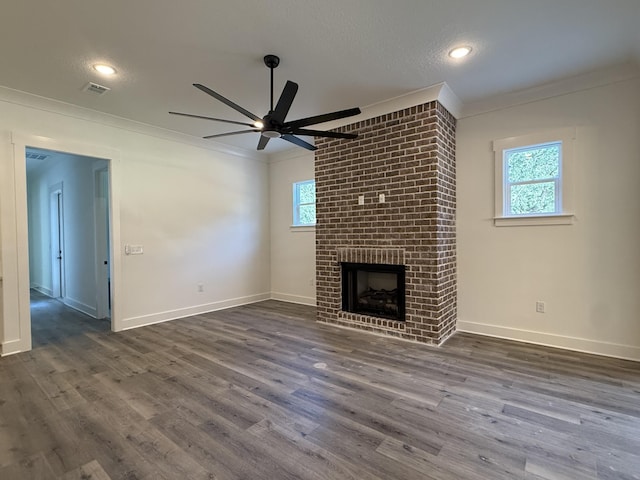 unfurnished living room with ornamental molding, a fireplace, and dark wood finished floors