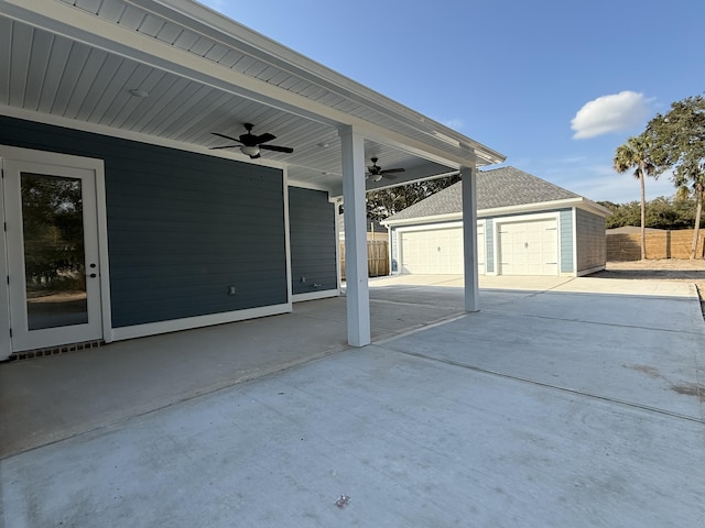 view of patio featuring ceiling fan, concrete driveway, an outdoor structure, and fence