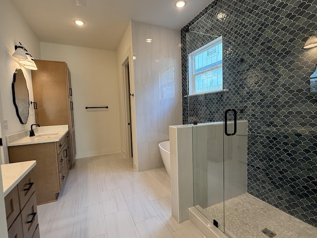 bathroom with a stall shower, a soaking tub, vanity, and recessed lighting