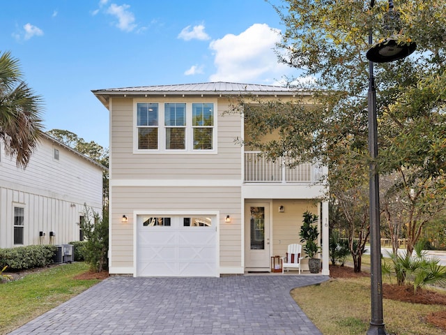 view of front of house featuring a garage, a balcony, and central AC