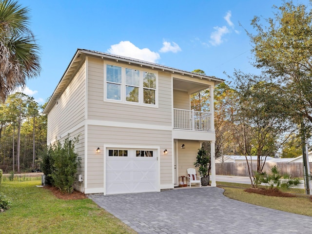 front facade with a garage, a balcony, and a front lawn