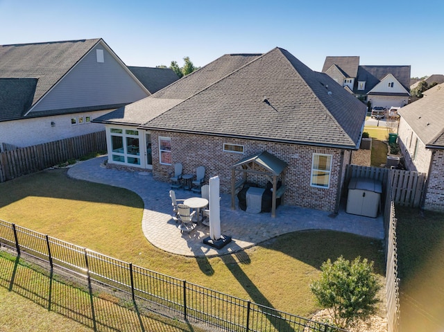 back of property with a yard and a patio