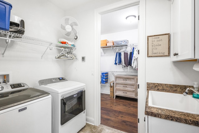 laundry room featuring washer and dryer, sink, and cabinets