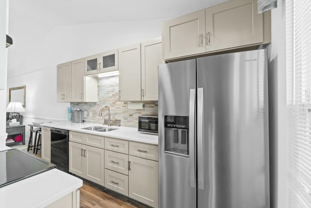 kitchen with stainless steel fridge, backsplash, sink, black dishwasher, and lofted ceiling