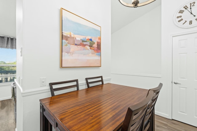 dining space with wood-type flooring and an inviting chandelier