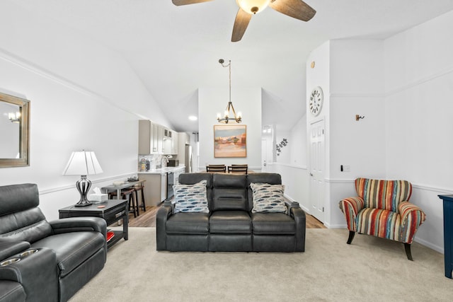 carpeted living room with sink, high vaulted ceiling, and ceiling fan with notable chandelier