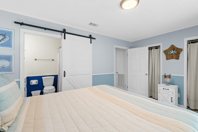 bedroom with a barn door and ensuite bathroom