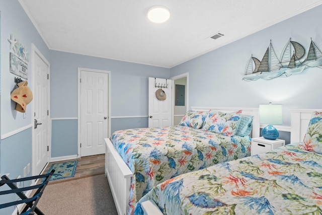 bedroom featuring dark carpet, crown molding, and electric panel