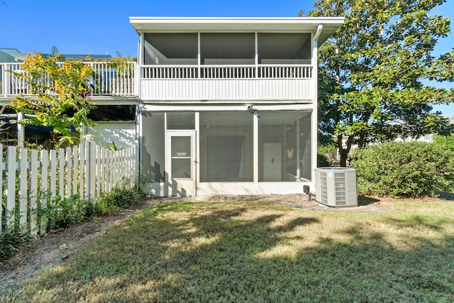 rear view of property featuring a lawn, central AC, and a sunroom