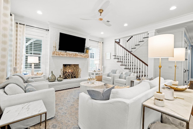 living room featuring crown molding, a fireplace, and ceiling fan