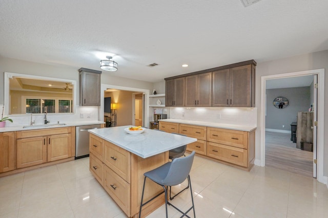 kitchen with sink, a center island, dishwasher, a kitchen breakfast bar, and backsplash