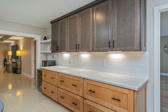 kitchen featuring light stone counters, light tile patterned floors, and decorative backsplash