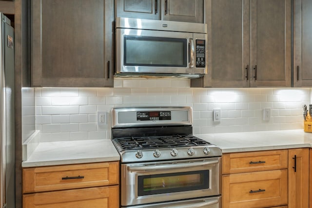 kitchen with light stone countertops, decorative backsplash, and appliances with stainless steel finishes