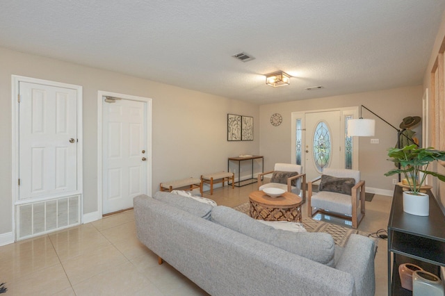 tiled living room featuring a textured ceiling