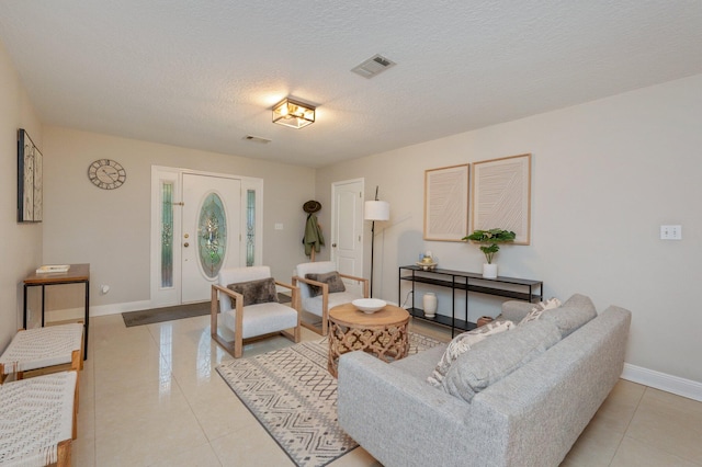 living room with a textured ceiling and light tile patterned flooring