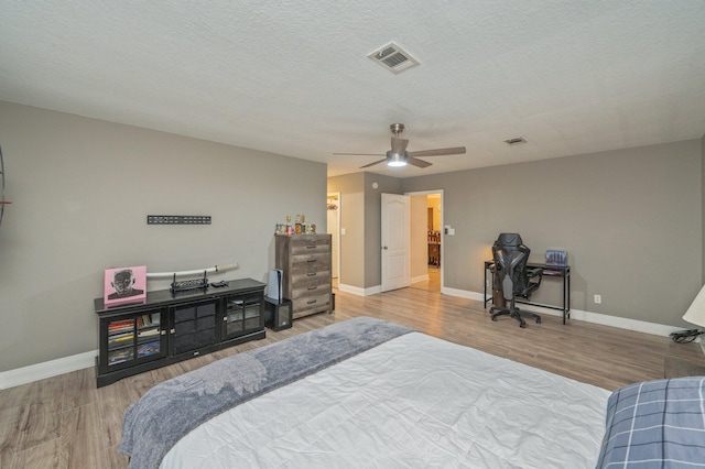 bedroom featuring ceiling fan, a textured ceiling, and hardwood / wood-style flooring