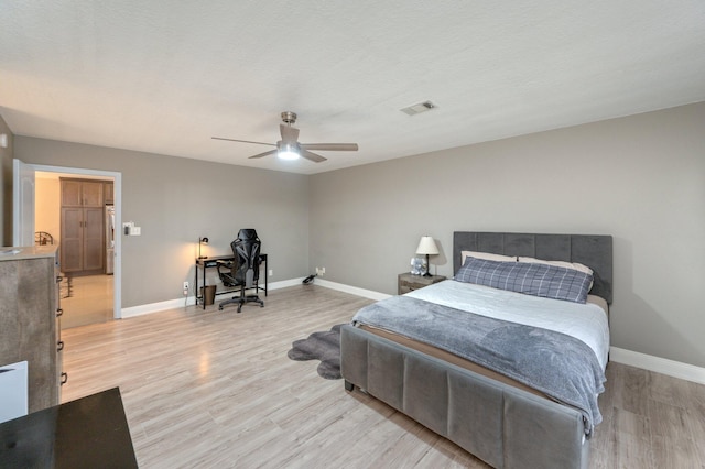 bedroom featuring a textured ceiling, ceiling fan, and light hardwood / wood-style flooring