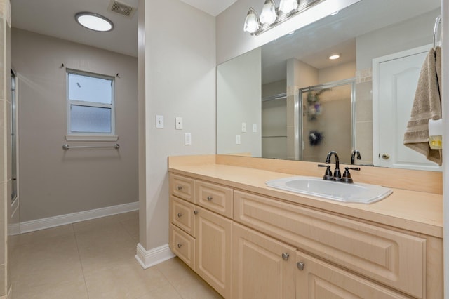 bathroom featuring vanity, tile patterned floors, and a shower with shower door