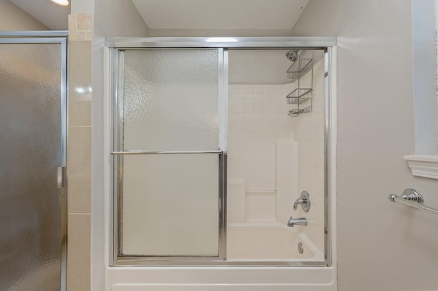 bathroom with shower / bath combination with glass door