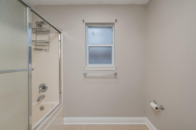 bathroom with shower / bath combination with glass door and tile patterned floors