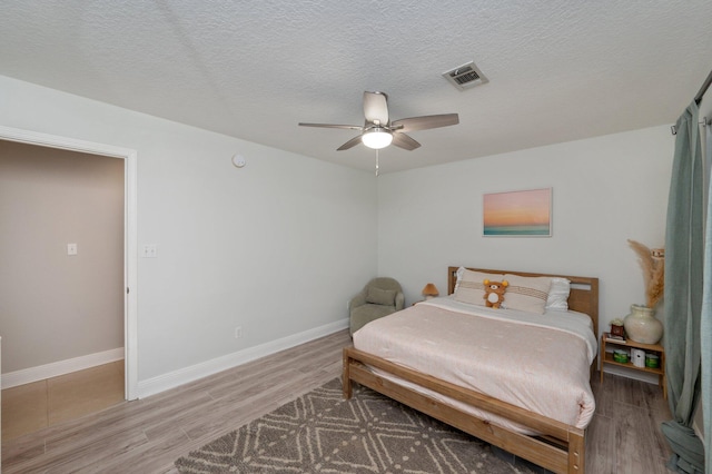 bedroom featuring ceiling fan, a textured ceiling, and hardwood / wood-style flooring