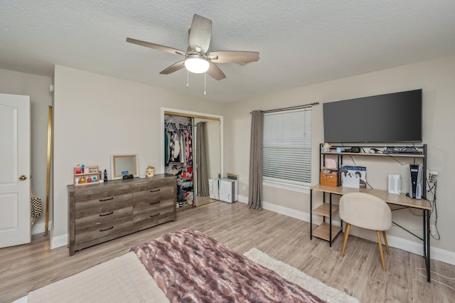 home office with a textured ceiling, ceiling fan, and light hardwood / wood-style flooring