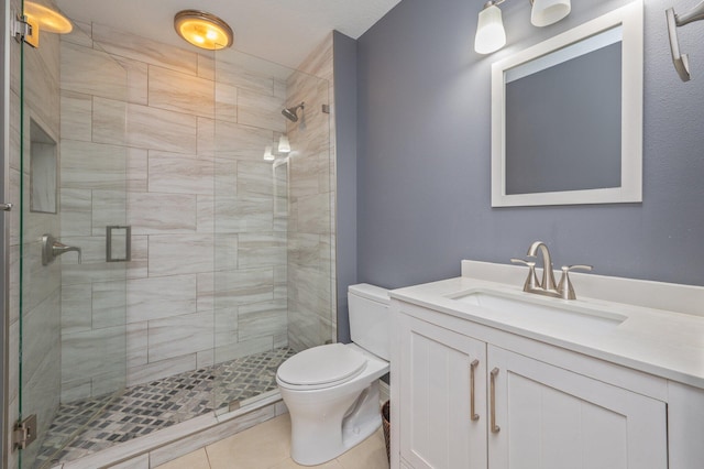 bathroom with toilet, vanity, tile patterned floors, and walk in shower