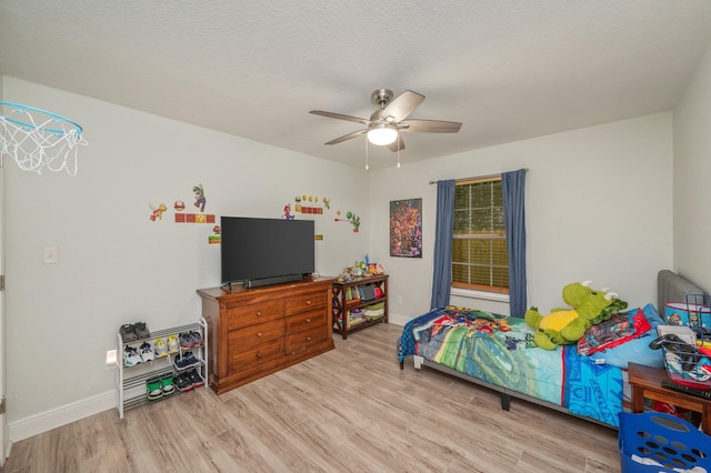 bedroom featuring ceiling fan, light wood-type flooring, and a textured ceiling