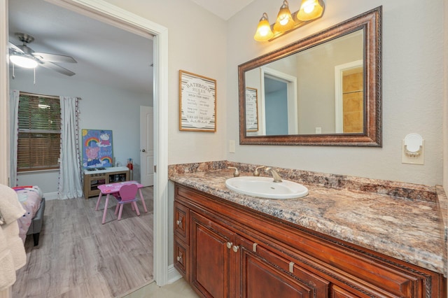 bathroom featuring hardwood / wood-style flooring, ceiling fan, and vanity