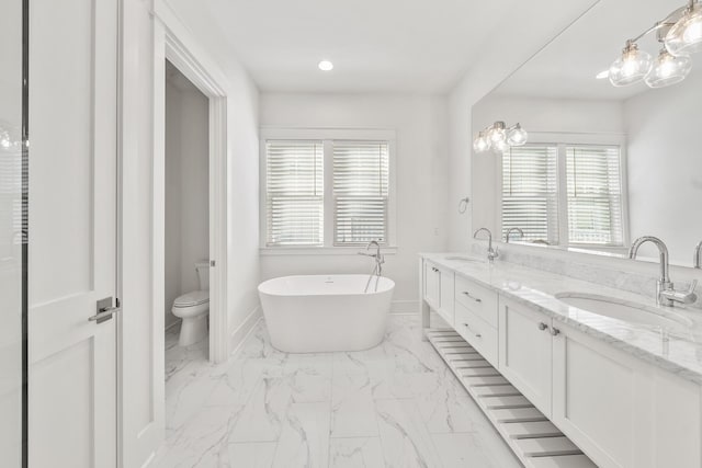 bathroom with vanity, a bath, and toilet