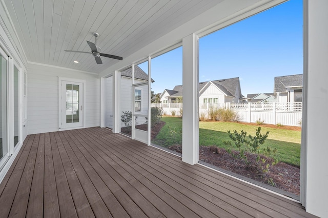 unfurnished sunroom with ceiling fan